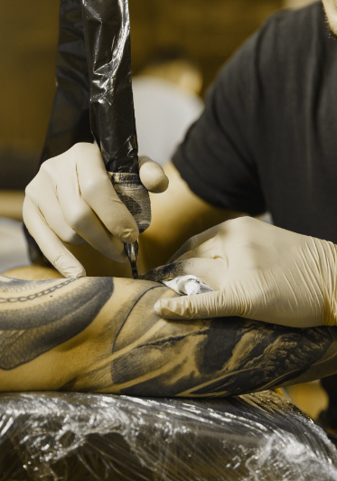 Tätowierer sticht ein Tattoo auf den Unterarm im Tattoo Studio Stuttgart